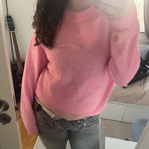 Rosa stickad tröja - Säljer en mysig rosa stickad tröja med långa ärmar. Perfekt för kyligare dagar och ger en skön och avslappnad look. Passar bra till jeans eller kjol för en casual stil.