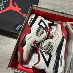 Air Jordan 4 Retro OG ‘Fire Red’ - Säljer ett par klassiska Nike Air Jordan sneakers i vitt, rött och svart. Skorna har snörning 