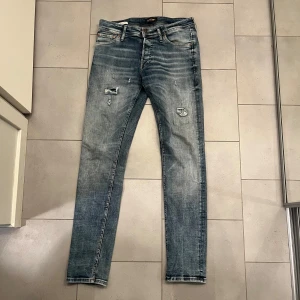 Blå jeansbyxor med slitningar från Jack and Jones - Snygga slim fit Glenn från Jack and Jones i storlek W30 L32