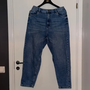 Blå jeans från XLNT - Säljer ett par klassiska blå jeans från XLNT. De har en elastisk midja för extra komfort och två bakfickor. Perfekta för en avslappnad stil.
