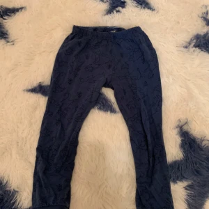 Mörkblå mjukisbyxor från Lupilu - Säljer ett par mörkblå mjukisbyxor/ pyjamasbyxor från Lupilu med ett subtilt mönster av djur och natur. Byxorna har en elastisk midja för extra komfort. Perfekta för lek och mysiga dagar hemma.