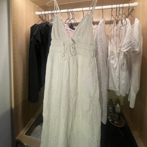 Vit långklänning med broderade detaljer - Fin klänning som inte kommer till användning. Klänningen har en v-ringad design och knytband i midjan för en justerbar passform. Fint skicka endast använd fåtal gånger. nypris 700kr 💕🌸