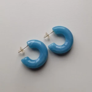 Blå örhängen - Snygga blå marmorerade örhängen med en glansig yta, i mycket bra skick. De har en enkel stiftstängning med transparenta bakstycken. Skriv vid frågor eller om du vill ha fler bilder. 