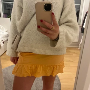 Orange kjol från Gina Tricot - Snygg orange kjol från Gina Tricot med volangdetaljer. Perfekt för att liva upp garderoben med en färgklick. Kjolen har en tight passform och är tillverkad i ett mjukt material.