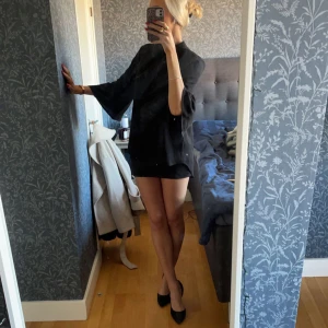 Svart blus - Snygg svart blus med trekvartsärmar och en lös passform. Perfekt för en stilren look. Blusen har en enkel design som gör den lätt att matcha med olika accessoarer.