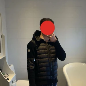 Svart dunjacka från Moncler - Snygg svart dunjacka från Moncler med huva och dragkedjan. Jackan har en quiltad design på framsidan och en praktisk ficka på ärmen. Perfekt för kyligare dagar. Det var en julklapp som inte passade i storlek!  Priset kan sänkas vid snabb affär!!!!