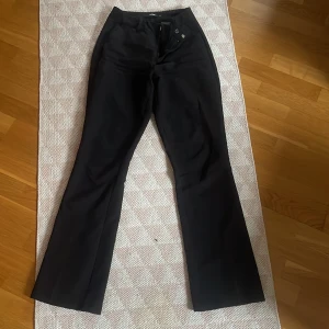 Svarta byxor från Bik Bok - Snygga svarta byxor från Bik Bok med bootcut-stil. De har en elegant passform och är perfekta för en stilren look. Byxorna är högmidjade och tillverkade i ett mjukt material som ger en bekväm känsla.