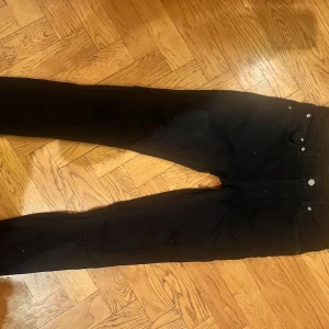 Svarta nudie jeans - Säljer svarta nudie jeans med custom made back logga men färgen går av lätt inga hål eller defekter!