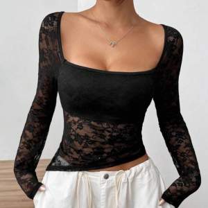 Elegant svart spetstopp med långärmad design och fyrkantig urringning. Perfekt för en stilren look med genomskinligt mönster som ger en sofistikerad touch. Det är storlek M men är som S på