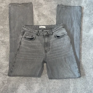 Gråa jeans från Gina Tricot - Snygga mid waist grå jeans från Gina Tricot med klassisk femficksdesign. De har en rak passform och är perfekta för en stilren look. Tillverkade i ett bekvämt denimtyg som ger en skön känsla hela dagen. Lite frasiga nere vid marken som kan ses på sista bilden 💕🌸