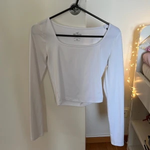 Vit långärmad topp från Hollister - Säljer en super mjuk  vit långärmad topp från Hollister. Toppen har en enkel design med en fyrkantig halsringning och är perfekt för lager-på-lager eller att bära som den är. Helt oanvänd!