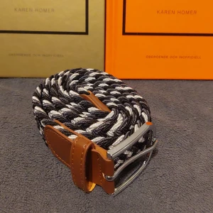 Flätat Bälte i Svart, Vit och Grå - Snyggt flätat bälte i svart, vit och grå. Helt nytt. Skick 10/10. 105 cm långt 