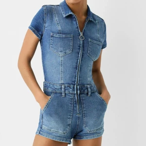 Kort jumpsuit i denim - Skitsnygg jumpsuit från Bershka💗Använd 1 gång! Säljer då den ej kommer till användning💕Nypris: 399kr