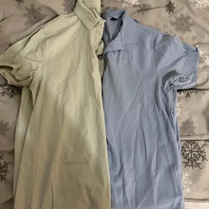 Två pikétröjor i beige och blå - Säljer två pikétröjor i mjukt material. Den ena är beige och den andra är ljusblå. Båda har korta ärmar och klassisk krage med knappar. Perfekta för en avslappnad stil.Pris kan diskuteras!!