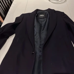 Marinblå  rock från Zara - Snygg marinblå rock från Zara i ull. Rocken har en klassisk design med en knappar framtill och är tillverkad av hållbart material. Perfekt för en stilren look.