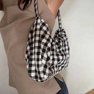 Rutig handväska i svartvit - Så cool hansväska med rutigt mönster i svart och vit. Finns inte att köpa längre. Något smutsig (se bild) men jag har aldrig testat tvätta den, det går troligtvis bort i tvätten.