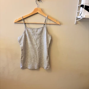 Grått Linne från H&M - Ett grått linne från hm som är ganska basic och bra som basplagg i storlek 146-152. Är i väldigt bra skick och typ aldrig använt💞 Linnet har smala axelband. Skriv för pris, bilder eller annat💙