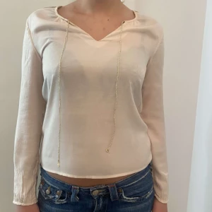Vit och guldig tröja - Säljer denna fina tröja som är vit med guldiga detaljer på ryggen och har band fram är väldigt sommrig och väldigt unik, säljes då den inte kommer till användnig i detta hemmet Står ej för postens slarv, finns katt i hemmet och pris går att diskutera