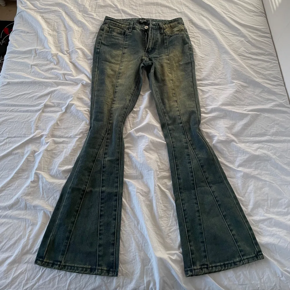 Säljer ett par snygga bootcut jeans i en klassisk blå färg. De har en skön passform och är perfekta för både vardag och fest. Jeansen har en dragkedja och knappar framtill samt fickor både fram och bak.. Jeans & Byxor.