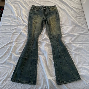 Bootcut jeans i blått - Säljer ett par snygga bootcut jeans i en klassisk blå färg. De har en skön passform och är perfekta för både vardag och fest. Jeansen har en dragkedja och knappar framtill samt fickor både fram och bak.