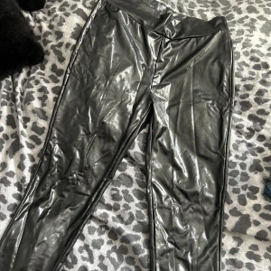 Svarta leggings från Bik Bok - Säljer ett par snygga svarta lackbyxor från Bik Bok. Aldrig använda så som nyskick