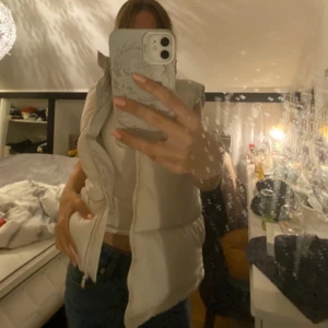 Vit täckväst  - Tjock täckväst i väldigt bra skick. Längden är lite över midjan men finns så det kan spännas åt, och använd bara några gånger.