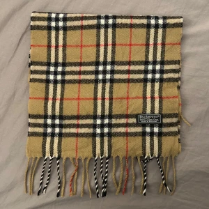 Burberry halsduk - Riktigt snygg och stilig halsduk från märket burberry, perfekt nu till vintern. Den är i bra skick utan defekter, vid frågor så är det bara att skriva🙌🏻🙌🏻