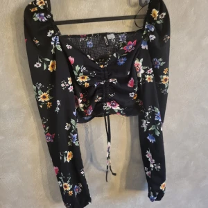Blommig tröja från Hm - Blommig tröja i Storlek S från hm. Går att justera med snöre fram och göra den kortare eller längre. Endast testad. 