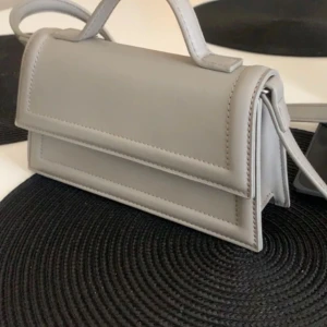 Gina tricot axelrämsväska - Snygg väska från gina, nypris 300. Helt ny. Den är lite beige/grå. Passa på med fri frakt!!💕