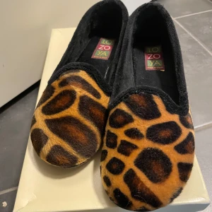Leopardmönstrade loafers från Lozoya - Snygga loafers med leopardmönster från Lozoya. Skorna har en mjuk och bekväm passform med svart kant och djärvt mönster i brunt och svart. Perfekta för att ge en touch av stil till din outfit.
