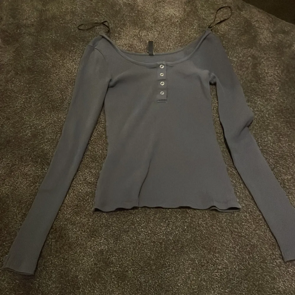 Snygg grå ribbad topp från Pieces med långa ärmar och knappar framtill. Perfekt för en stilren look.. Yläosat.