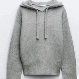 Grå hoodie från Zara - Mysig grå hoodie från Zara med justerbar dragsko i huvan. Tröjan har långa ärmar och ribbstickade muddar vid ärmslut och nederkant. Perfekt för kyliga dagar.