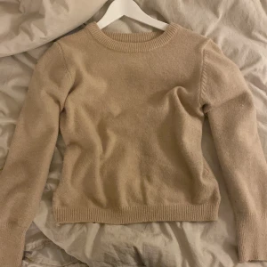 Beige stickad tröja från Vila - Mysig beige stickad tröja från Vila i mycket bra skick. Perfekt för höst och vinter med sin varma och sköna känsla. Tröjan har långa ärmar och en rund halsringning med ribbade kanter. Passar både till vardags och lite finare tillfällen. 🧶✨
