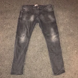 Svarta jeans från Hilfiger Denim - Snygga svarta jeans från Hilfiger Denim med en klassisk femficksdesign. De har en diskret tvättad look och knappgylf. Perfekta för en stilren vardagslook.