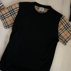 Svart t-shirt från Burberry - Säljer en trendig svart t-shirt från Burberry. Väldigt bra skick och billigt pris. Använts max 2 gånger.