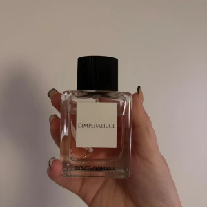 L'Imperatrice parfym från Dolce & Gabbana - Säljer en elegant parfymflaska av L'Imperatrice från Dolce & Gabbana. Flaskan är genomskinlig med en stilren vit etikett och ett svart lock. Perfekt för den som älskar fräscha och fruktiga dofter. Passar både till vardags och fest!