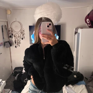 Svart pelsjacka  - Mysig svart pels jacka i mycket bra skick. Perfekt för kyliga höst- och vinterdagar. Jackan har en dragkedja framtill och långa ärmar. Den är både stilren och bekväm, vilket gör den idealisk för vardagsbruk. Passar perfekt till jeans eller leggings för en avslappnad look.