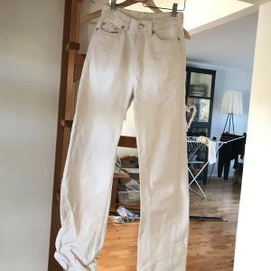 Beig/vita jeans från Weekday rowe - Säljer ett par snygga beige jeans från Weekday i modellen Rowe. De är i bra skick och har en klassisk femficksdesign. Perfekta för både vardag och fest! 🕺