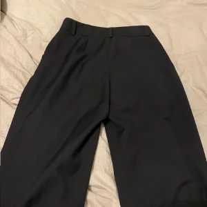 Svarta kostymbyxor - Snygga svarta kostymbyxor med hög midja och en klassisk rak passform. Använda 2-3ggr och inga defekter. Stl S