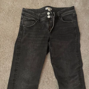 Grå jeans från Gina Tricot - Snygga grå jeans från Gina Tricot med klassisk femficksdesign och dubbla knappar i midjan. Strl 164 🥰