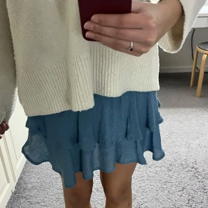 Blå volangkjol - Snygg blå kortkjol med volanger. Perfekt för en somrig look. Kjolen har en elastisk midja för bekväm passform. Går även att använda som en topp (se bild 3) Märke och storlek står ej men skulle säga att den passar XS/S💕