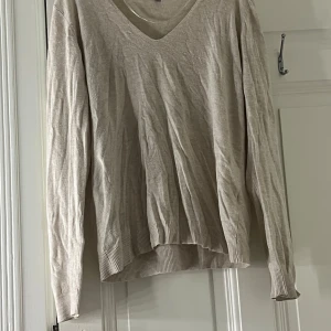 Beige tröja från Basic You - Säljer en stilren beige tröja från Basic You i storlek M. Tröjan har en v-ringad hals och långa ärmar, perfekt för en avslappnad look. Den är tillverkad i ett mjukt material som känns skönt mot huden. ( har andvänt få gånger)
