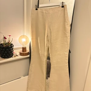 Linnebyxor från Wera - Snygga beige linnebyxor från Wera. Byxorna är vida/utsvängda och är mid waist.