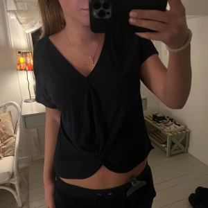 Mörkblå v-ringad topp - Säljer en svart v-ringad topp med korta ärmar och en knutdetalj framtill 🎀🎀