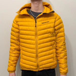 Gul dunjacka från Peak Performance - Gul dunjacka från Peak Performance i väldigt bra skick! Modellen är 185cm och väger70kg!
