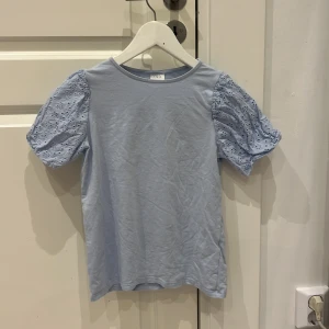 Ljusblå topp med spetsärmar - Söt ljusblå topp från Zara med korta spetsärmar. Perfekt för vår och sommar. Den har en rund halsringning och en normal passform.