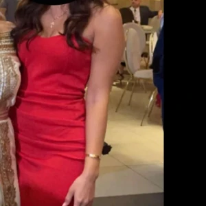 Röd långklänning - Elegant röd långklänning med en tight passform. Klänningen har en klassisk design som framhäver figuren och är perfekt för festliga tillfällen.