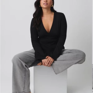 Svart tie top från Gina Tricot  - Säljer nu min svarta tie top ifrån Gina Tricot i storlek S, tröjan har ett snöre runt midjan som man kan justera själv hur tajt man vill att den ska sitta, den är även utsvängd i ärmarna. Ny pris är 299kr men tröjan är endast använd 1 gång så säljer den nu för 200kr.