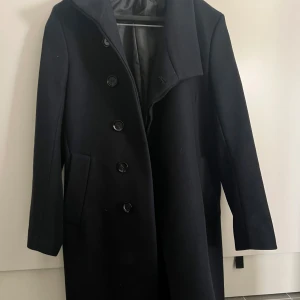  Rock från Zara - Fin mörkblå rock från Zara med knappar framtill. Den har en klassisk design med långa ärmar och en stilren krage. Väldigt sparsamt använd.