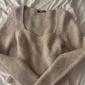 Beige ribbad tröja från Gina Tricot - Mysig beige ribbad tröja från Gina Tricot med långärmad design. Perfekt för kyligare dagar med sin stickade struktur och bekväma passform.